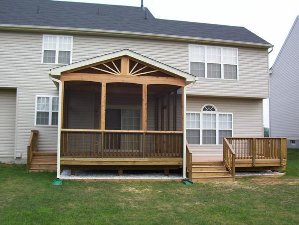 Composite Decking with wood frame built in Butler MD by Nevins Construction.  Left side of deck has a wooden screen room.