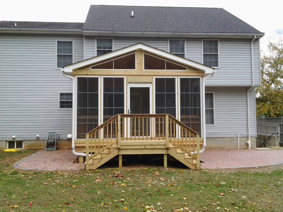 Nevins Construction built a wooden deck and screen room with a landing to a set of steps on each side.